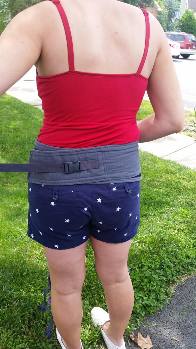 If needed, tighten the hip belt by pulling the tether